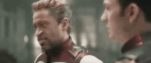 Two Men Are Standing Next To Each Other And Talking To Each Other . GIF