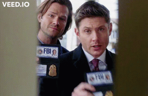 Two Men Are Standing Next To Each Other Holding Badges That Say Fbi GIF