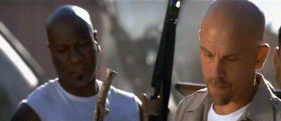 Two Men Are Standing Next To Each Other Holding Guns GIF