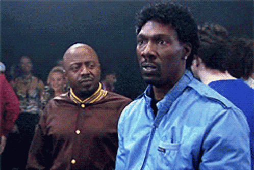 Two Men Are Standing Next To Each Other In A Crowd And One Of Them Is Wearing A Blue Jacket With The Word Reebok On It GIF