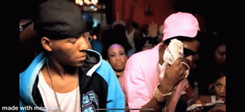 Two Men Are Standing Next To Each Other In A Crowd Of People . GIF