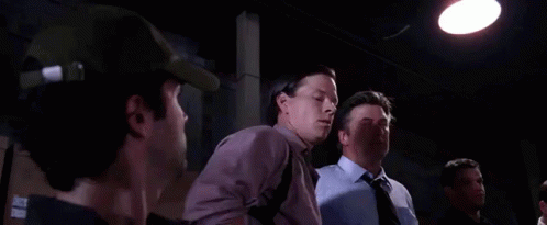 Two Men Are Standing Next To Each Other In A Dark Room And One Of Them Is Saying You Must Be The Other Guy . GIF