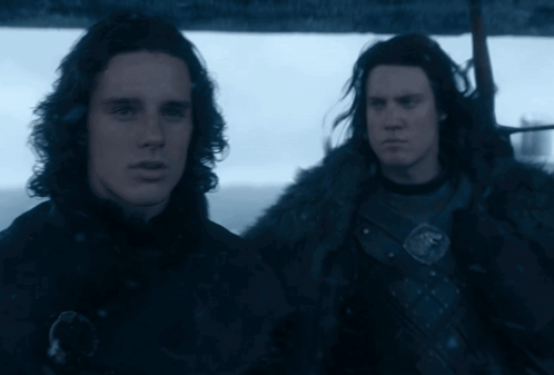 Two Men Are Standing Next To Each Other In A Dark Room GIF