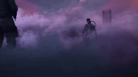 two men are standing next to each other in a dark room surrounded by smoke .