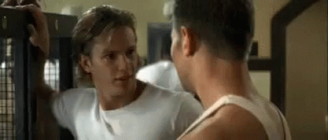 Two Men Are Standing Next To Each Other In A Gym And Talking . GIF