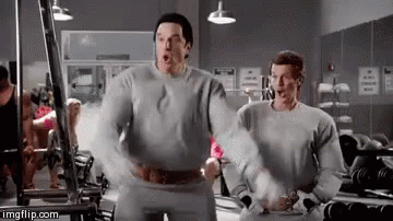 Two Men Are Standing Next To Each Other In A Gym With Their Arms Outstretched . GIF