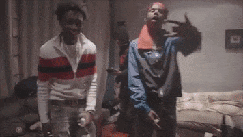 Two Men Are Standing Next To Each Other In A Living Room And Making A Peace Sign . GIF