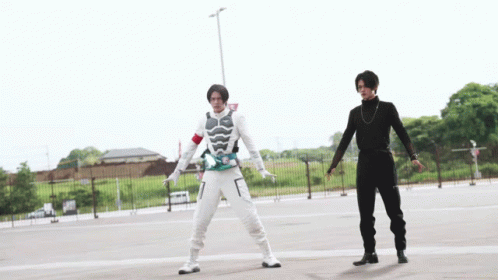 Two Men Are Standing Next To Each Other In A Parking Lot GIF