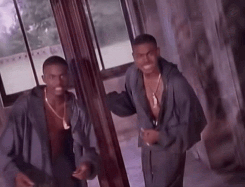 Two Men Are Standing Next To Each Other In A Room GIF