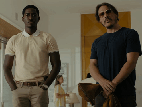 Two Men Are Standing Next To Each Other In A Room GIF