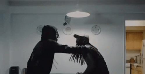 Two Men Are Standing Next To Each Other In A Room And Fighting . GIF