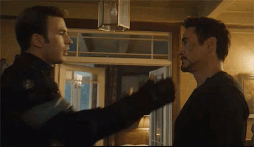 Two Men Are Standing Next To Each Other In A Room And Talking . GIF