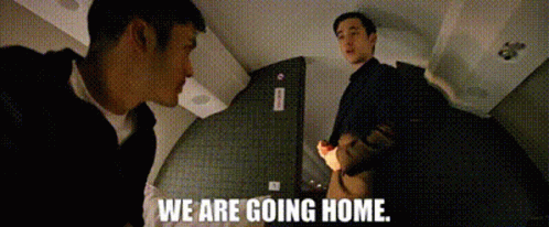Two Men Are Standing Next To Each Other In A Room And The Words `` We Are Going Home '' Are Written On The Screen . GIF