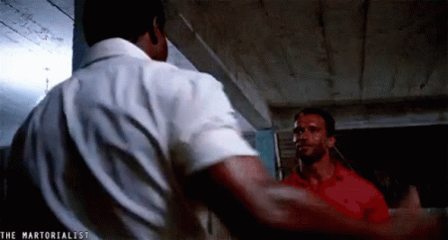 Two Men Are Standing Next To Each Other In A Room . GIF