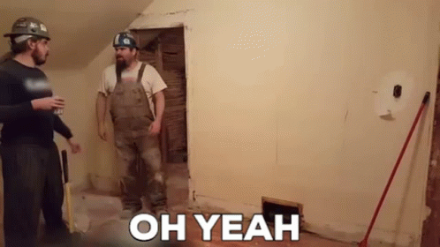 Two Men Are Standing Next To Each Other In A Room With The Words `` Oh Yeah '' On The Wall . GIF