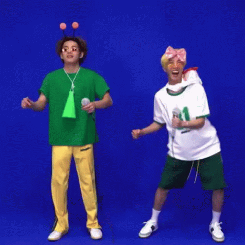 Two Men Are Standing Next To Each Other In Front Of A Blue Background And Holding Microphones . GIF