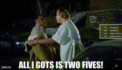 two men are standing next to each other in front of a car and one of them is holding another man .