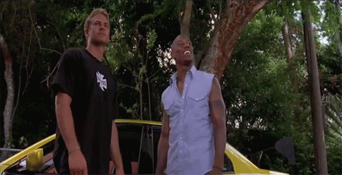 Two Men Are Standing Next To Each Other In Front Of A Car GIF