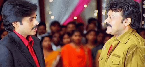 Two Men Are Standing Next To Each Other In Front Of A Crowd And Talking To Each Other . GIF