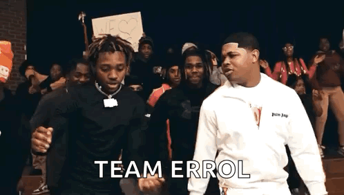Two Men Are Standing Next To Each Other In Front Of A Crowd Of People And Holding Hands . GIF