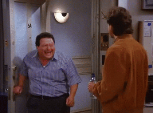 Two Men Are Standing Next To Each Other In Front Of A Door With The Number 5A On It GIF