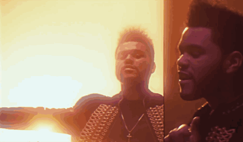 Two Men Are Standing Next To Each Other In Front Of A Fire GIF