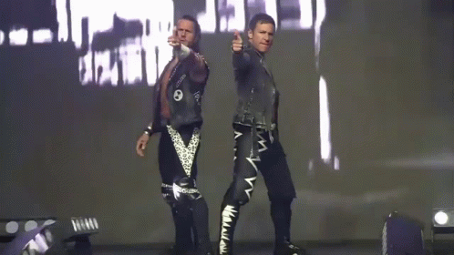 Two Men Are Standing Next To Each Other In Front Of A Large Screen With The Word Death On It GIF