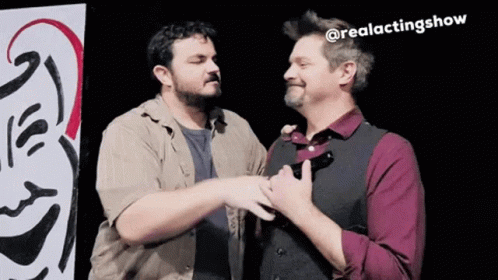 Two Men Are Standing Next To Each Other In Front Of A Sign That Says @Realactingshow . GIF