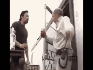 Two Men Are Standing Next To Each Other In Front Of A Trailer . GIF