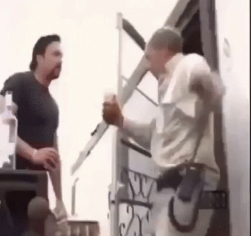 two men are standing next to each other in front of a trailer .