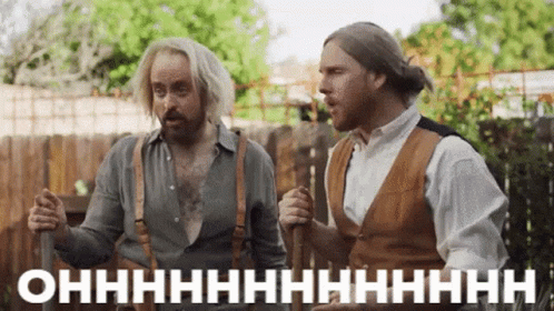Two Men Standing By Wooden Fence GIF