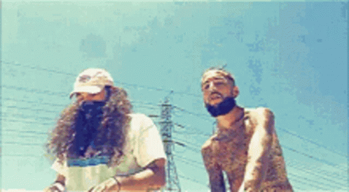 Two Men Are Standing Next To Each Other In Front Of Power Lines GIF