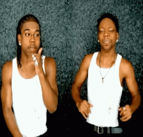 Two Men Are Standing Next To Each Other In White Tank Tops GIF