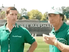 Two Men Are Standing Next To Each Other On A Field With The Words `` We Are Marshall '' Written On The Bottom . GIF