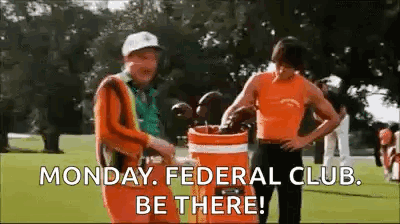Two Men Are Standing Next To Each Other On A Golf Course Holding Golf Clubs In A Golf Bag . GIF