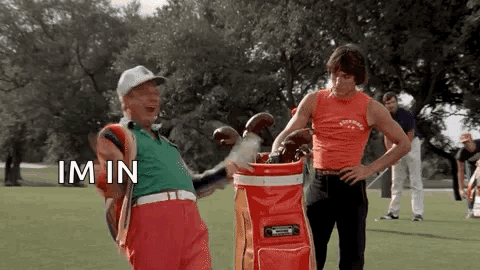 Two Men Are Standing Next To Each Other On A Golf Course . GIF
