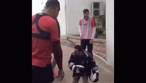 Two Men Are Standing Next To Each Other On A Sidewalk . GIF