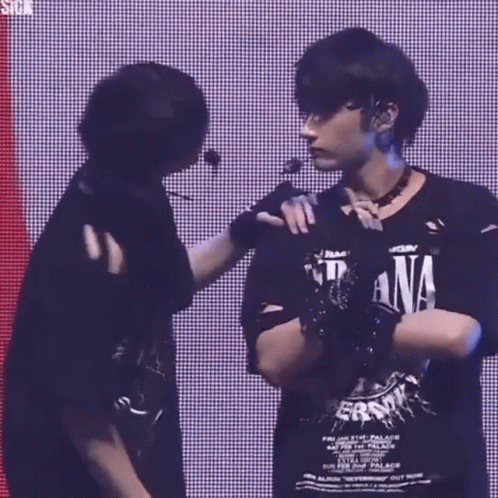 two men are standing next to each other on a stage .