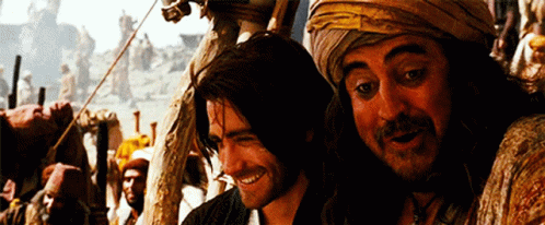 Two Men Are Standing Next To Each Other Smiling And Looking At The Camera GIF