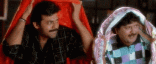 Two Men Are Standing Next To Each Other Under A Red Cloth . GIF