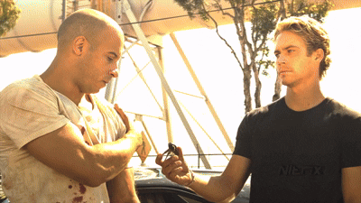 Two Men Are Standing Next To Each Other With One Wearing A Black Shirt That Says Wes-Fix GIF
