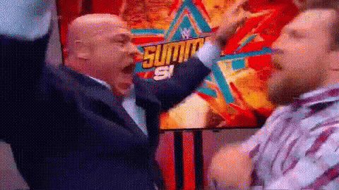 Two Men Are Standing Next To Each Other With Their Arms In The Air In Front Of A Poster . GIF