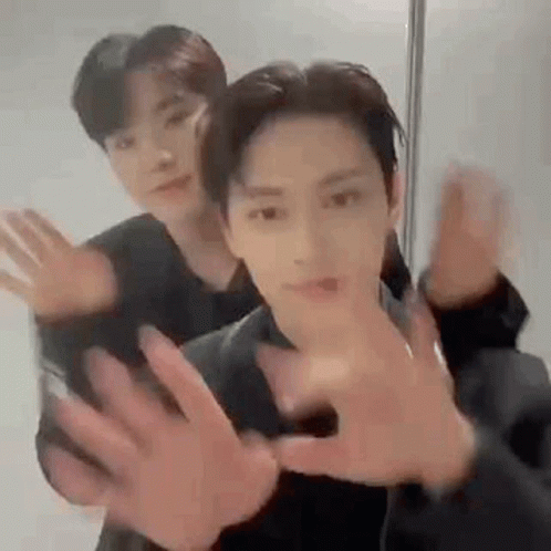 Two Men Are Standing Next To Each Other With Their Hands Outstretched . GIF