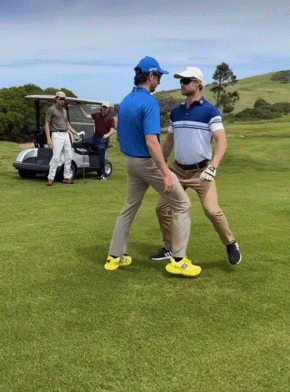 Two Men Are Standing On A Golf Course And One Is Wearing Yellow Shoes GIF