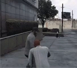 Two Men Are Standing On A Sidewalk In Front Of A Building And A Tree GIF