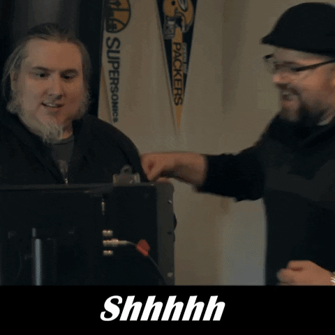 Two Men Are Talking In Front Of A Sign That Says " Packers " GIF