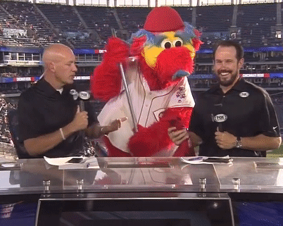 Two Men Are Talking To A Mascot Wearing A Fox Logo GIF