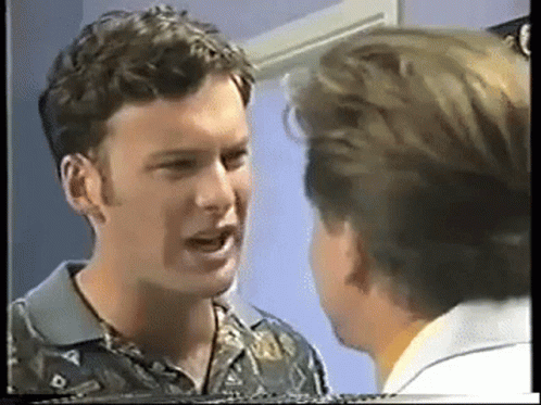 Two Men Are Talking To Each Other In A Room GIF
