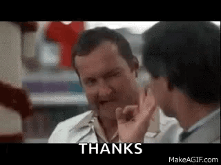 Two Men Are Talking To Each Other In A Store And One Of Them Is Giving A Thumbs Up Sign . GIF