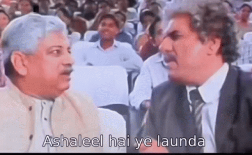 Two Men Are Talking To Each Other In Front Of A Crowd Of People . GIF